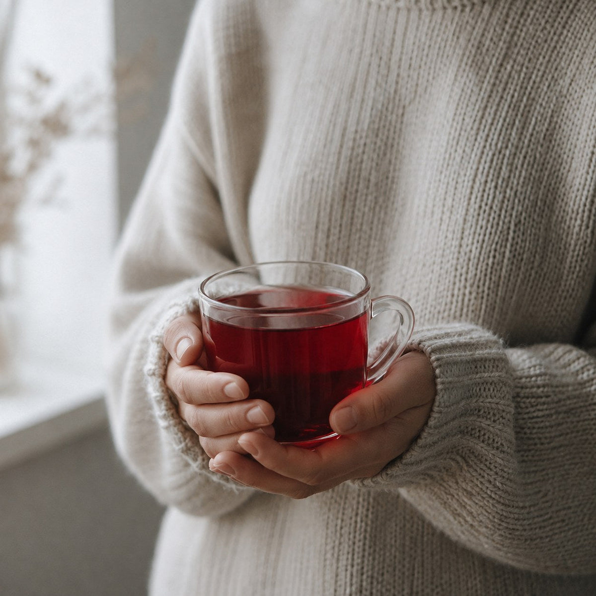 Holding a glass mug of hibiscus tea