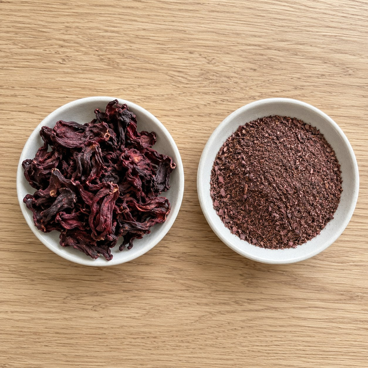 Two bowls compared, whole dried hibiscus calyces beside ground hibiscus dust