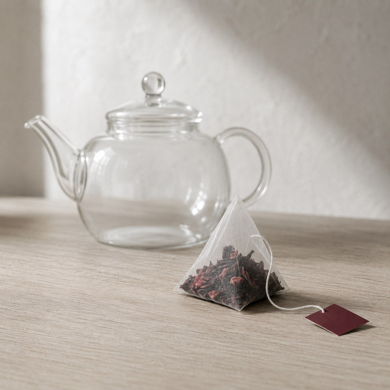 A TERO tea bag going into a clear glass mug